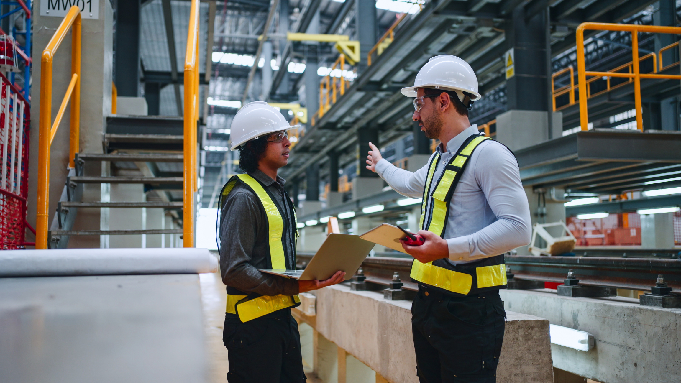 Engineer working with laptop in railway workshop for engineering industry or transportation concept.
